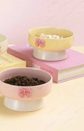 Bol surélevé en céramique avec nœud : trois coloris blanc crème, jaune et rose garnis de croquettes et friandises