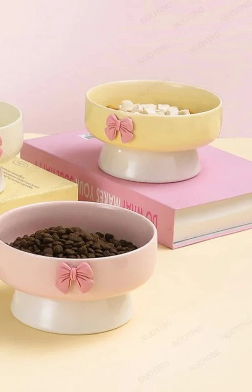 Bol surélevé en céramique avec nœud : trois coloris blanc crème, jaune et rose garnis de croquettes et friandises