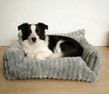 Canapé en velours côtelé gris avec un border collie couché dessus, sur un parquet clair