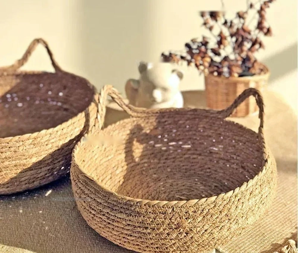 Deux paniers nid en herbe tressée vides, avec oreilles de chat, posés sur une table